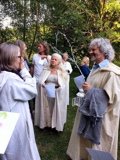 Penny Billington and Philip Carr-Gomm chat, while Eimear Burke looks on.  All are robed after a ritual held at the Earthspirit centre in 2017.